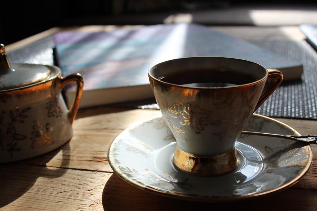 A close up of a cup and saucer on a wooden table.