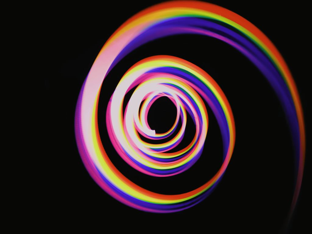Spiralling rainbow light against a black background